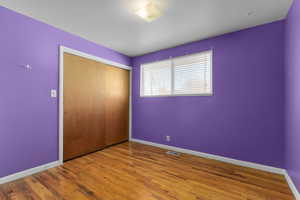 Unfurnished bedroom featuring a closet and light hardwood / wood-style flooring