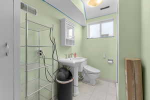 Bathroom featuring toilet, tile patterned floors, and sink