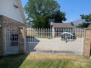 View of gate featuring a mountain view and a yard