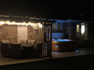 Patio at twilight with a pergola and a hot tub