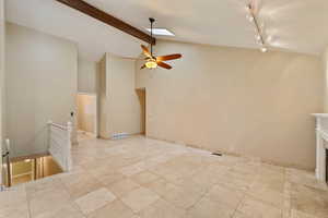 Family room with ceiling fan, lofted ceiling with skylight, and track lighting