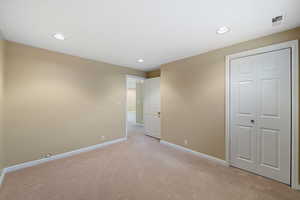 Bedroom 5 featuring light carpet and a closet