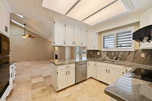 Kitchen featuring white cabinetry, ceiling fan, kitchen peninsula, vaulted ceiling, and black appliances