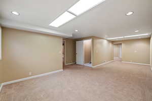 Basement featuring light colored carpet