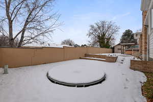 Backyard in ground trampoline and sandbox/garden area