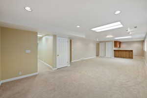 Basement with light carpet and a wet bar