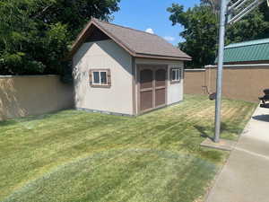 View of shed with a lawn