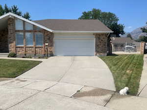 View of front of property with a garage and a front lawn