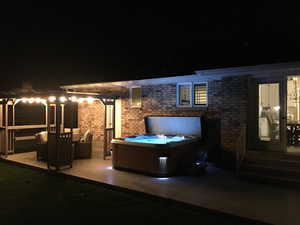 Patio at night with a hot tub