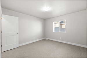 Carpeted spare room with a textured ceiling