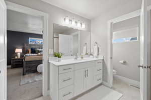 Bathroom with vanity, a textured ceiling, and toilet