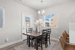 Dining space with wood-type flooring and a notable chandelier