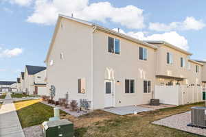 View of side of home featuring a yard, central AC unit, and a patio area