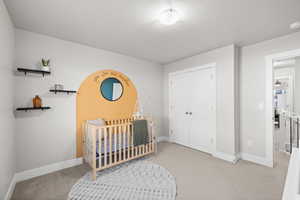 Carpeted bedroom featuring a closet and a textured ceiling