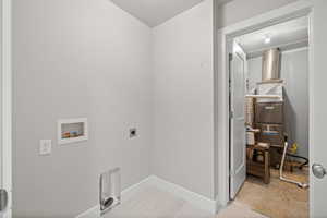 Clothes washing area featuring washer hookup and hookup for an electric dryer