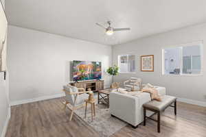 Living room with ceiling fan and light wood-type flooring