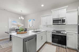 Kitchen featuring appliances with stainless steel finishes, white cabinetry, and sink