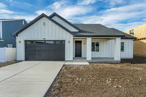 Modern inspired farmhouse featuring a porch and a garage