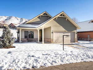 Snow covered property featuring a mountain view and a garage