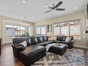 Living room featuring ceiling fan and dark wood-type flooring