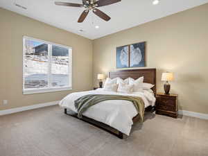 Bedroom with ceiling fan and light colored carpet