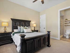 Bedroom with ensuite bathroom, ceiling fan, and light carpet