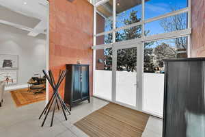 Interior space with a towering ceiling and light tile patterned flooring
