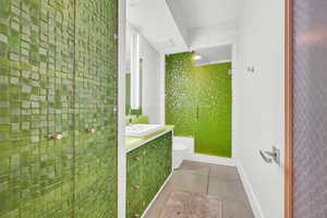 Bathroom with toilet, vanity, and tile patterned floors
