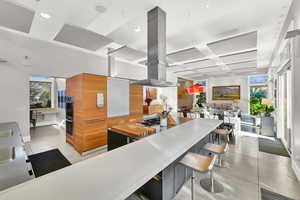 Kitchen with island range hood, a kitchen bar, and stainless steel double oven