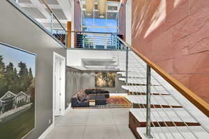 Stairway with tile patterned floors and a high ceiling
