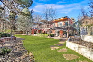 Exterior space featuring a patio area, a yard, and a balcony