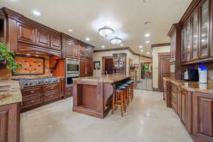 Kitchen featuring sink, a kitchen bar, crown molding, and appliances with stainless steel finishes