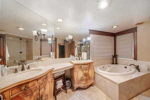 Bathroom featuring plus walk in shower, vanity, and tile patterned floors