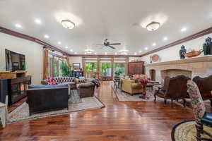 Living room with hardwood / wood-style flooring, ceiling fan, crown molding, and french doors