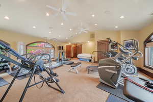 Exercise room with carpet floors, ceiling fan, and lofted ceiling