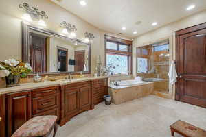 Bathroom featuring vanity and independent shower and bath