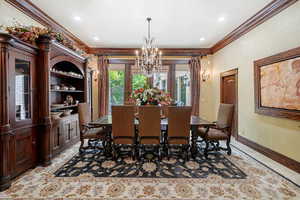 Dining area featuring a chandelier, built in shelves, and ornamental molding