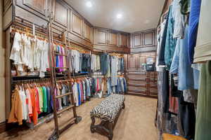 Walk in closet with light carpet