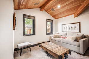 Living room featuring carpet flooring, lofted ceiling with beams, and wood ceiling