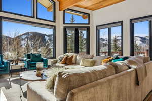 Sunroom / solarium with a mountain view, beam ceiling, and wood ceiling