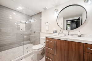 Bathroom with vanity, toilet, and an enclosed shower