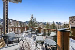 Snow covered deck featuring a mountain view