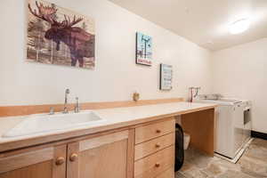 Washroom featuring cabinets, separate washer and dryer, and sink