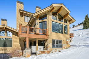 Snow covered property featuring a balcony