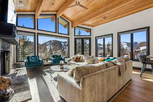 Living room featuring a mountain view, hardwood / wood-style flooring, beamed ceiling, and wood ceiling