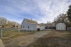 View of side of property with a storage shed and lots of parking