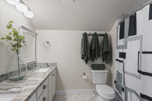 Bathroom with walk in shower, vanity, a textured ceiling, vaulted ceiling, and toilet