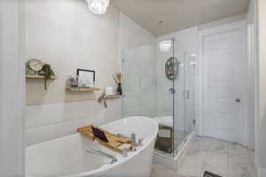 Bathroom with independent shower and bath and a notable chandelier