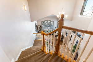 Stairs featuring carpet and a notable chandelier