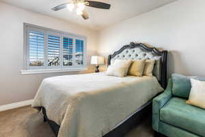 Carpeted bedroom featuring ceiling fan